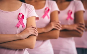 Een groep vrouwen met roze shirts en een Pink Ribbon.