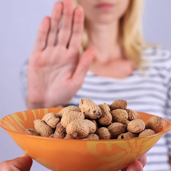 Afwijzend gebaar naar aangeboden schaal met pindanoten