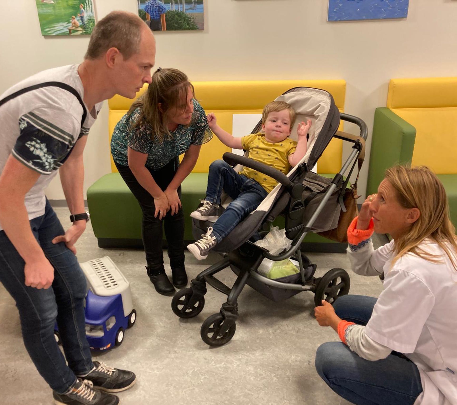 Een groep mensen kijkt naar een baby in een kinderwagen.