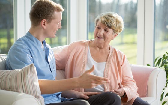 Man and woman are talking to each other on the couch.