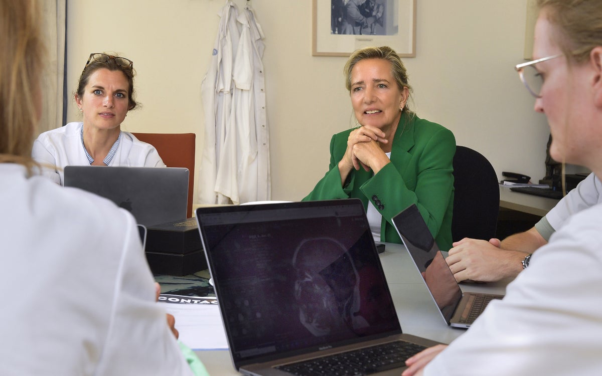 Carina Hilders met zorgverleners rond een tafel met laptops