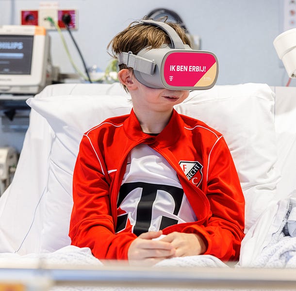 Thomas in een ziekenhuisbed met FC Utrecht kleding en VR-bril