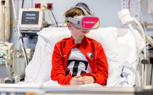 Thomas in een ziekenhuisbed met FC Utrecht kleding en VR-bril
