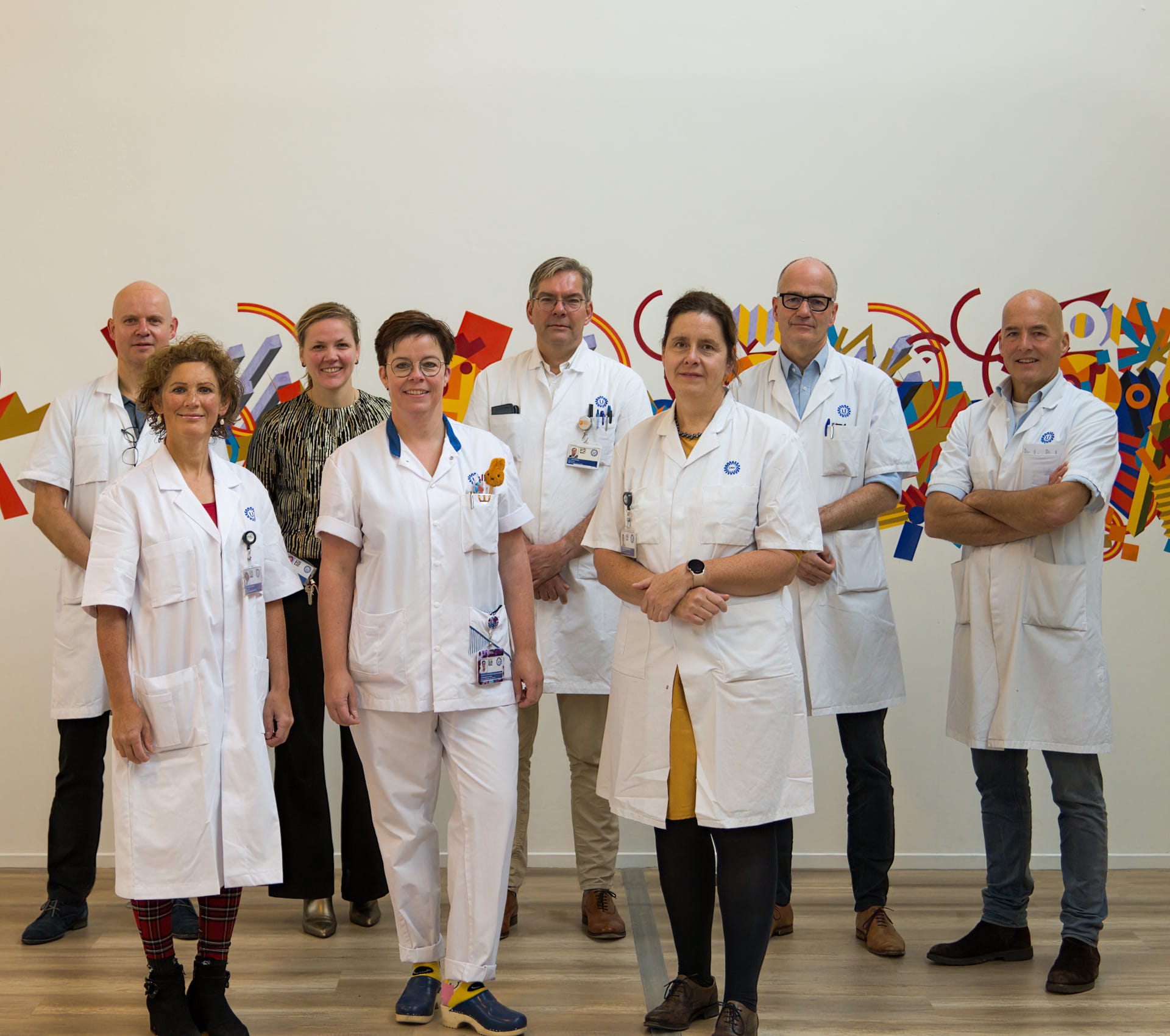 Acht leden van de groep Hoofd-halskanker in witte jassen.