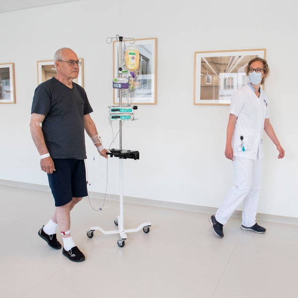 Patiënt met beweegsensor loopt samen met een fysiotherapeut