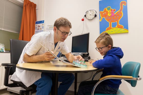 dokter laat een kind narcose spullen zien