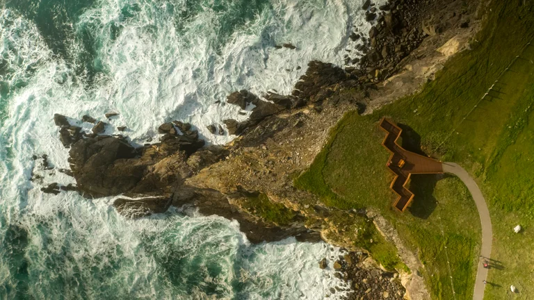 Aerial view of the coastline and waves with viewing platform on Skellig Centre