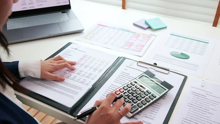 A person using a calculator and a calculator