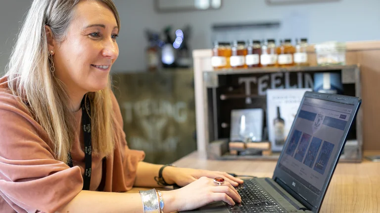 A woman sitting at a table using a laptop