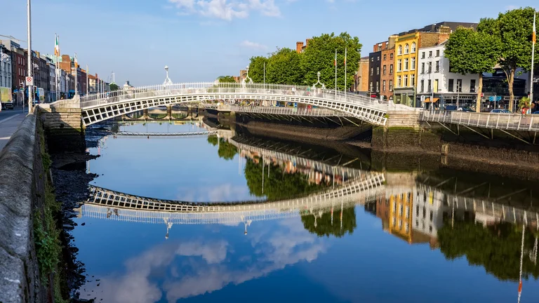 A white bridge over a river in a city