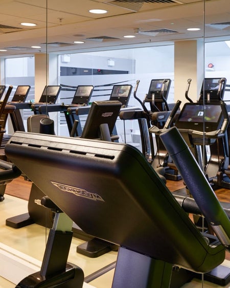 Cardio machines in a modern gym with treadmills and exercise bikes