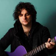 Paddy Casey - a man looking down at a guitar he is playing