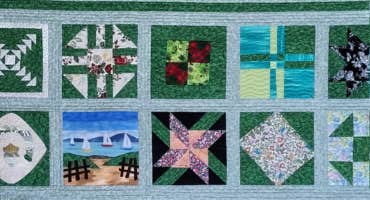 Exhibition: Thread Therapy, Irish Patchwork Society North Eastern Branch, a patchwork quilt mostly in shades of blue and green.