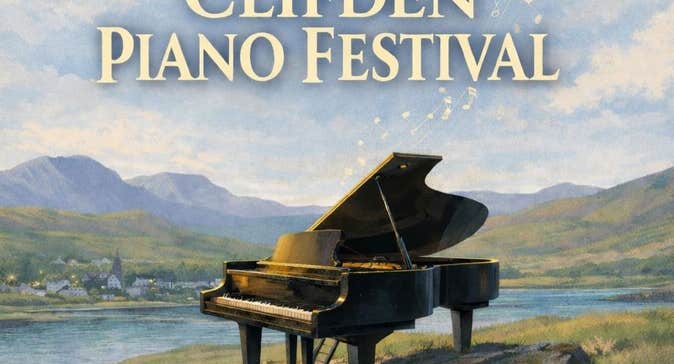 Painting of a grand piano on rocks overlooking water, mountains and small town in the distance.