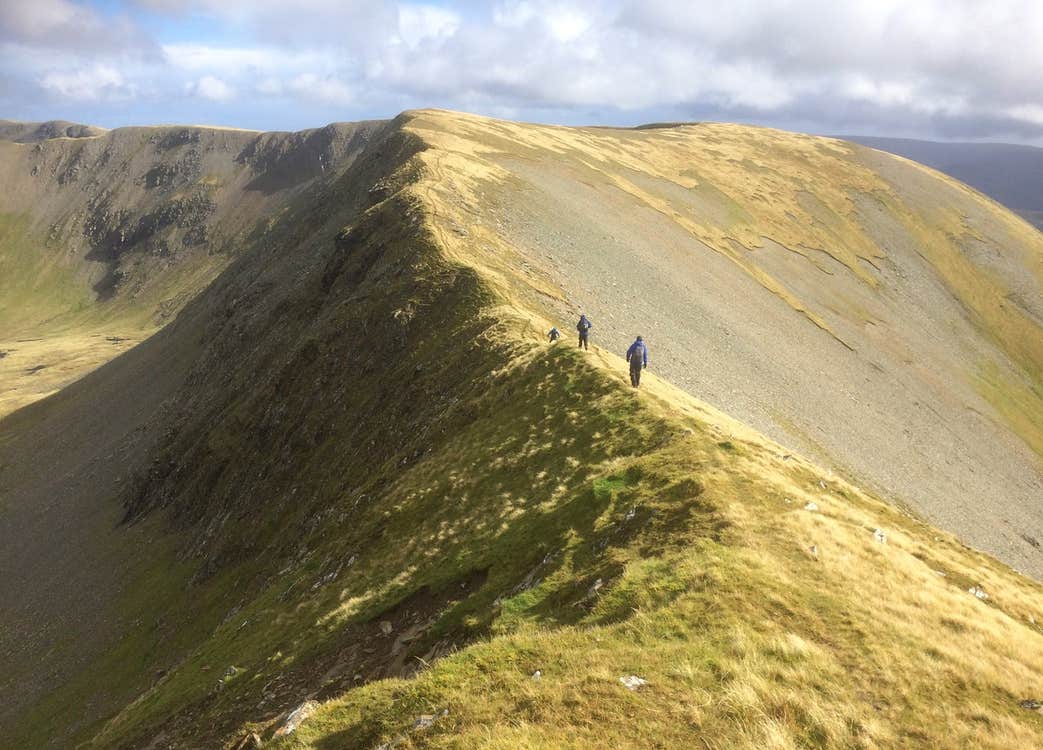 Two people walking along a mountain ridge