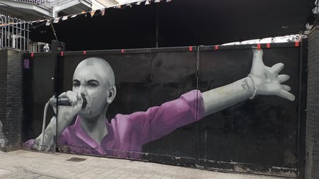 Mural of a singer wearing a pink shirt holding a microphone