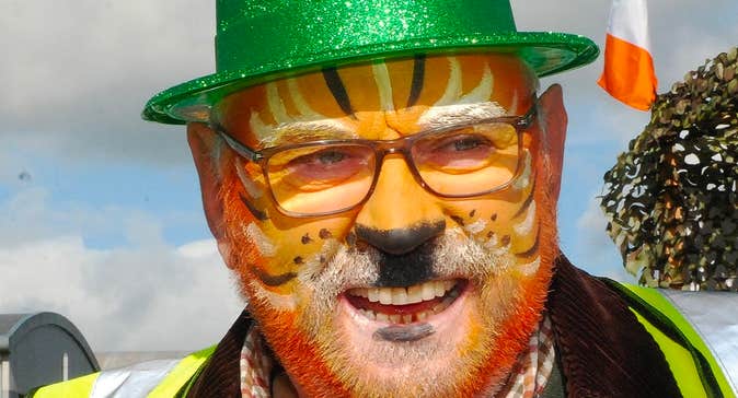 Roscrea Goes Green - St Patrick’s Day Parade, a man with painted orange cat face and sparkly green hat.