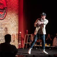 Friday Night Live - Friday, 20th March 2026, a man on a small stage with a mic, pointing at the audience.