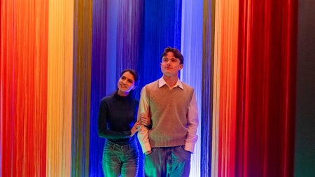 Couple walking through a rainbow coloured room