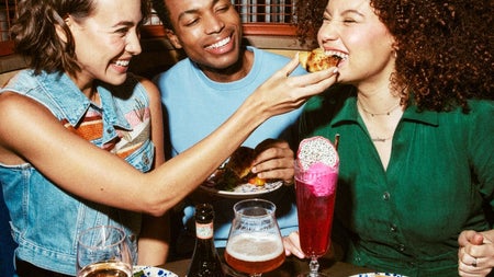 Three people at a table with pasta dishes