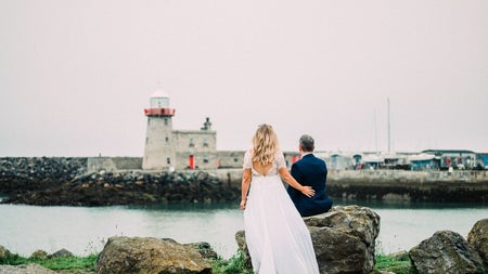 A wedding couple looking at the lighthouse