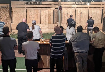 Group of people in a wooden area with targets for axe throwing