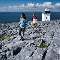 People walking along Black Head Lighthouse in the Burren, Co Clare