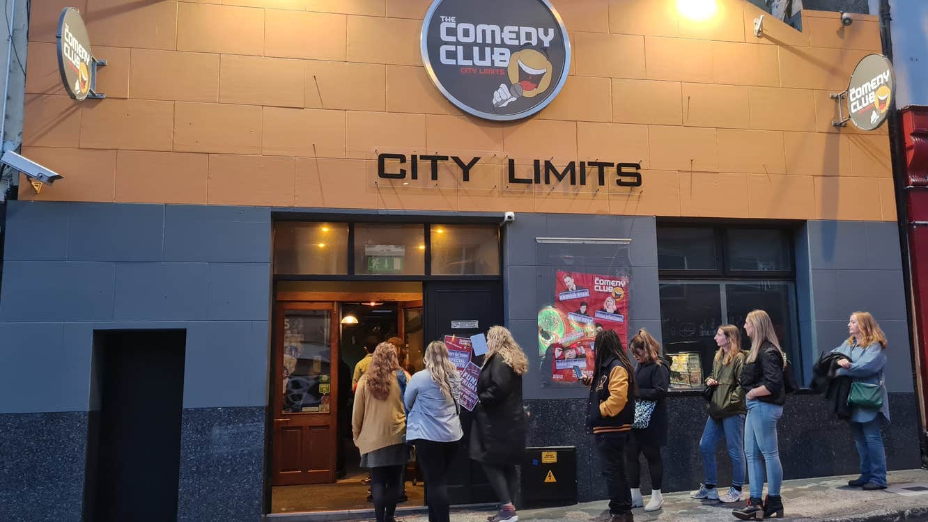 Best of Cork November Autumn Special - people queueing outside a building at night.