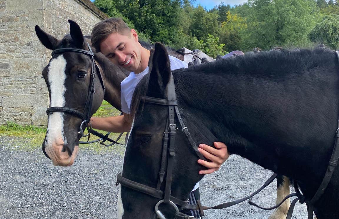 Greg O'Shea petting two horses at Birr Equestrian Centre