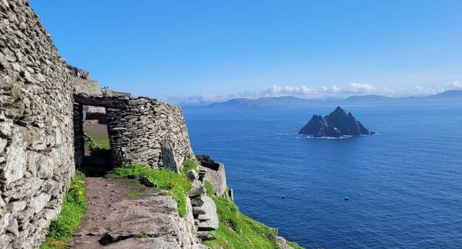 Stone and grass pathway on an island in the sea with another island in the background