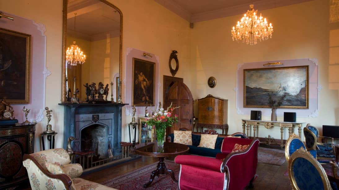 A chandelier, fireplace and furniture in the grand interior of Kinnitty Castle