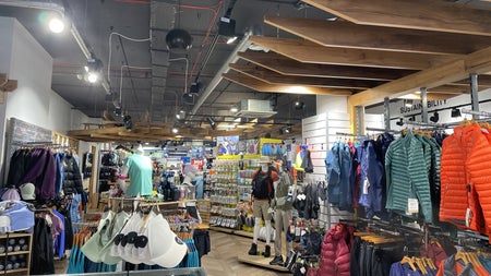 Shop floor with rows of different coloured clothes on hangers
