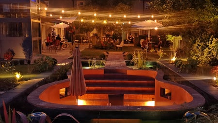 A view of the outdoor seating area and garden at La-La Café & Restaurant