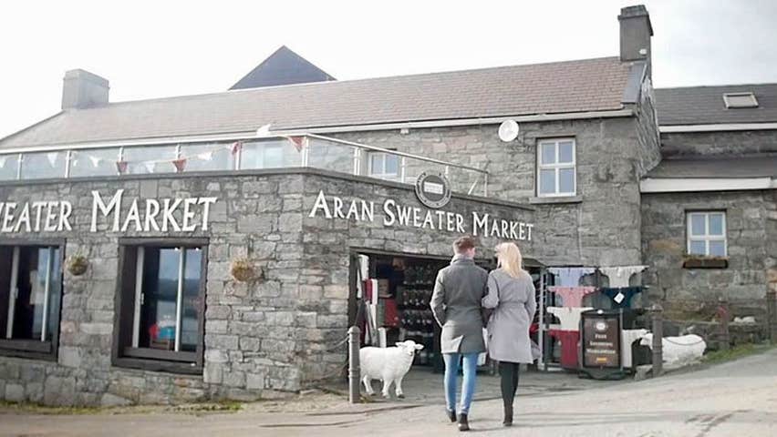 A couple walking arm in arm towards the entrance of the aran sweater market on Inis Mor Aran Islands