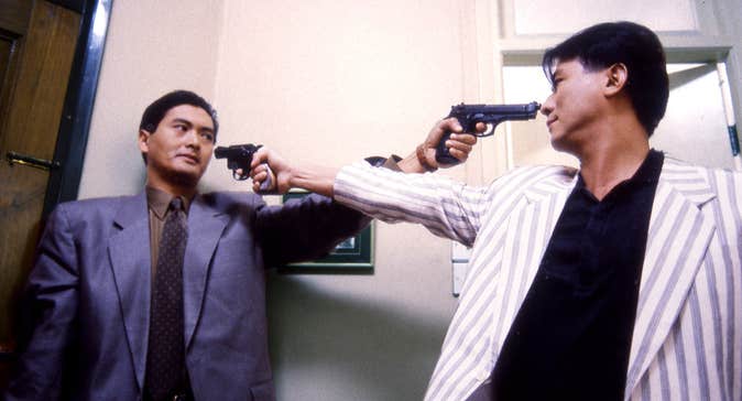 Two men pointing pistols at each other.