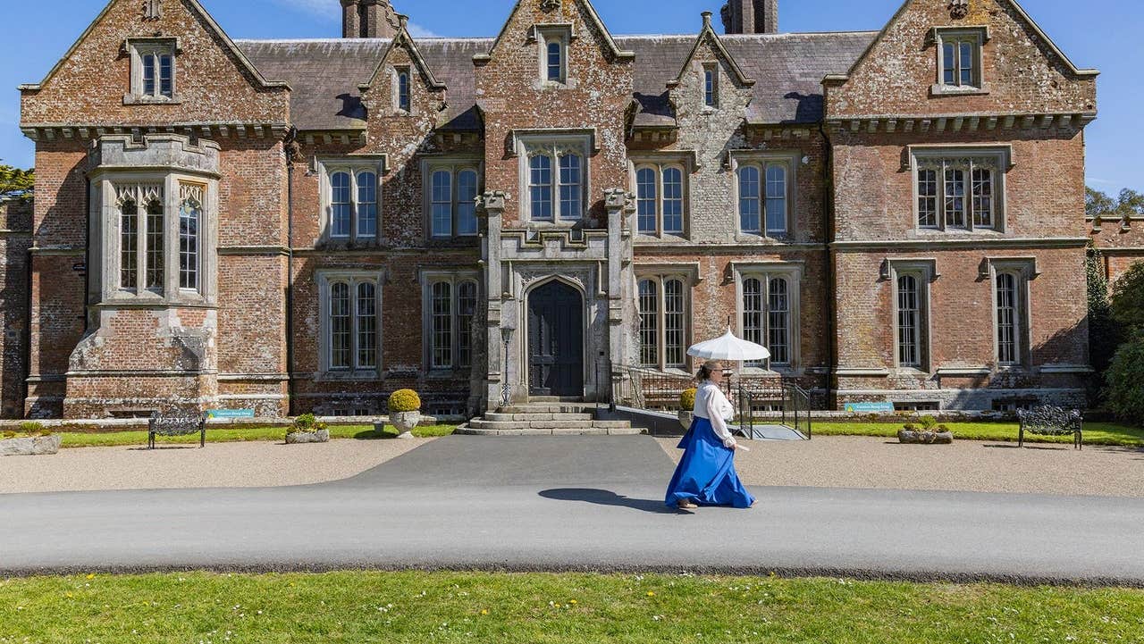 Lady in costume walking in front of Wells House