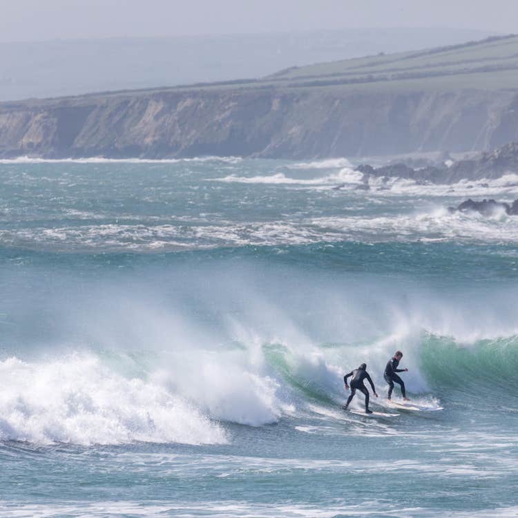 Two people surfing the big waves at Garrettstown