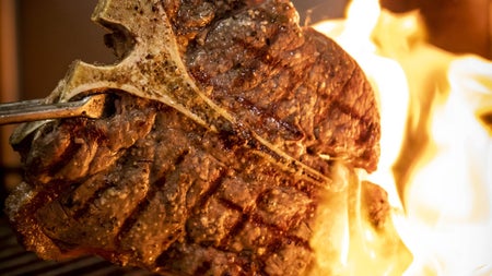 Flamed steak being cooked on a grill