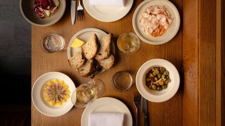 View looking down over a table full of dishes from the menu at Comet