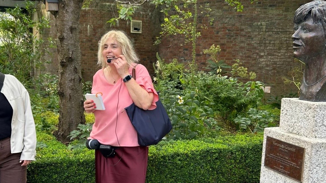 Tour Guide speaking to a tour group at the Veronica Memorial Statue in Dublin Castle Garden