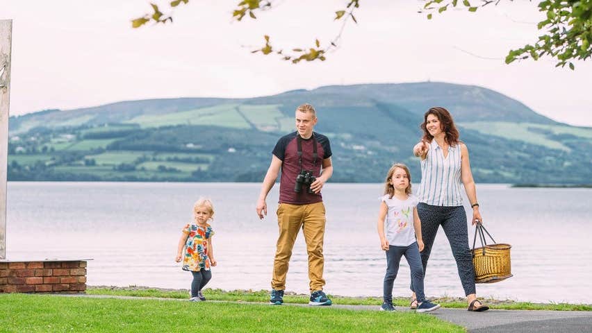 A family walking along a lake shoreline
