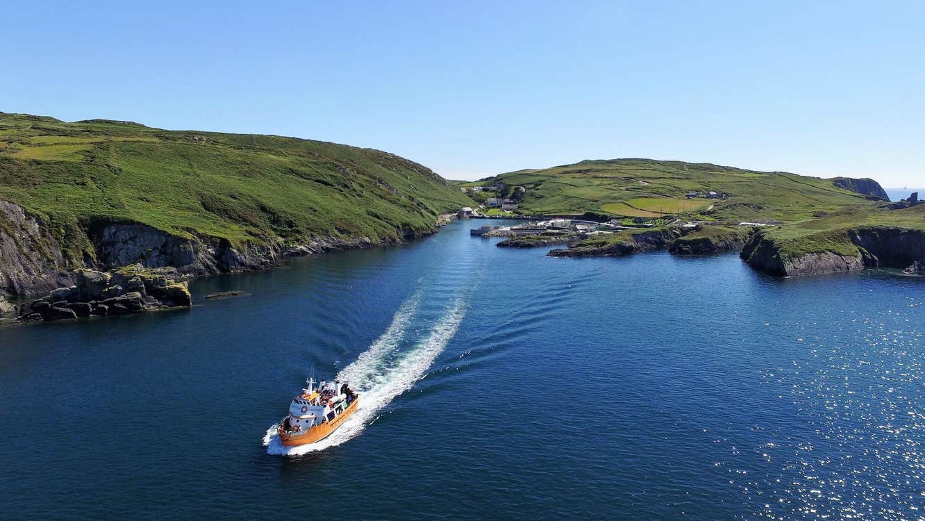 A drone image of a ferry sailing away from land