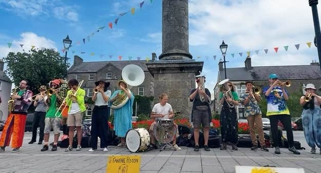 Birr Vintage Week & Arts Festival 2026, a large group of musicians playing outdoors standing in a line under a tall column