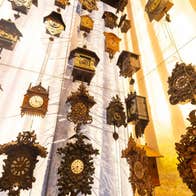 A wall display of suspended assorted cuckoo clocks