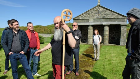 Lambay Nature Walking Tours group by a chapel with a guide holding a decorated staff