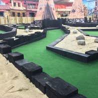 An indoor play area for kids with sand and small buildings to explore