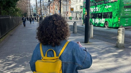 A woman on a city street looking up at buildings