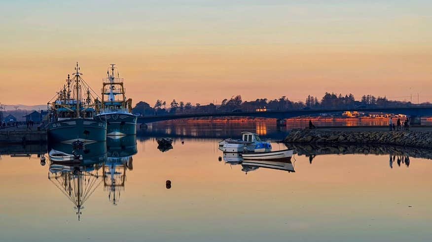 Four boats on still water at Wexford Harbour, County Wexford at sunset.