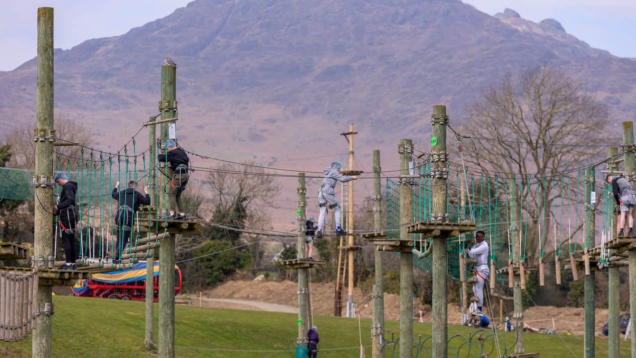 Children walking along suspended rope bridges