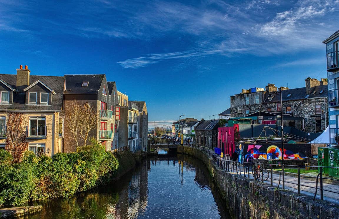 A view of apartments and street art along the still waters of Eglington Canal in Galway.